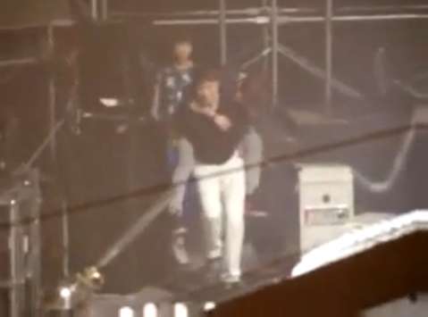 Onew is being carried by his manager after fainting